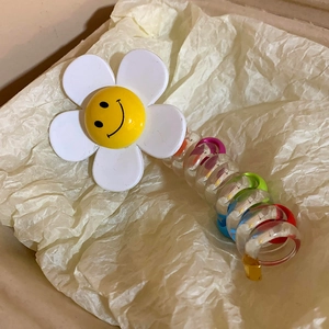 Détail d'élastique spirale transparent avec fleur smiley et anneaux intérieurs colorés