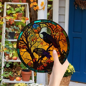 Macro view of a stained glass crow ornament showing light filtering through autumn leaves