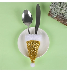 Dettaglio portaposate a mini cappello di Babbo Natale con paillettes dorate su piatto