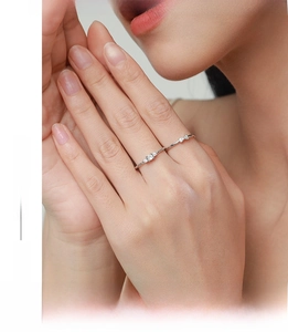 Dettaglio di eleganti anelli in argento S925 con design a fiocco e piccoli diamanti lucidi