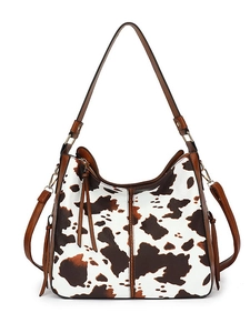 Vintage cow print tote bag with brown leather shoulder straps and fringe on white background