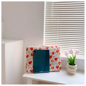 Quilted cotton laptop sleeve featuring red heart patterns and a white textile label