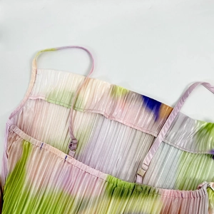 Detail of adjustable straps and gradient tie-dye pleated fabric on a slim-fit dress