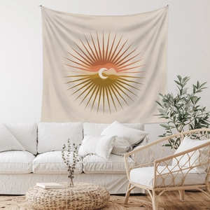 Detail of bohemian sun and moon tapestry hanging above a modern living room sofa