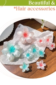 Close-up of eight gradient plastic flower hair claws with colorful pistil centers