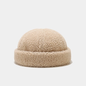 Close-up of beige sherpa docker hat fabric texture showing warm grainy fleece material