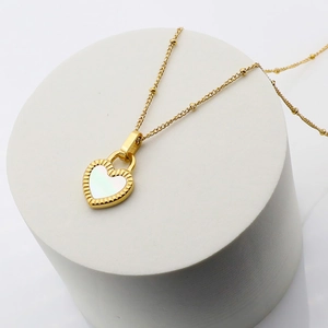 Detail of 18K gold plated heart pendant with white shell inlay and elegant bead chain