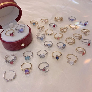 Flat lay of diverse adjustable rings with colorful crystals and floral shell motifs