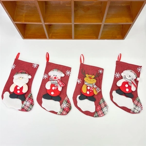 Set of four burlap Christmas stockings with Santa and Snowman hanging on a white wall