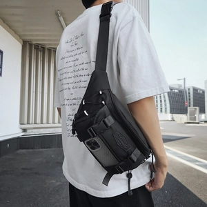 Black techwear crossbody chest bag with nylon material and adjustable strap outdoors
