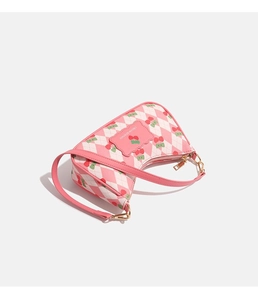 Vue détaillée du sac à bandoulière rose à motif losanges avec imprimés cerises et dorures