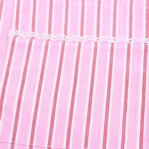 Detailed macro view of pink and red striped cotton fabric with delicate white lace trim