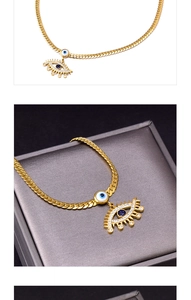 Détail du pendentif œil maléfique doré avec cristaux bleus sur chaîne serpent plate