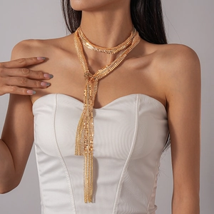 Detailed view of layered gold tassel necklace with metallic fringe on model