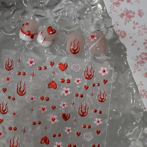 DIY nail stickers featuring red heart and flame patterns with finished faux nails
