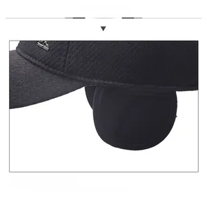 Detail view of winter baseball cap with ear flaps and metallic logo on knit texture