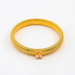 Detailed view of flexible gold-tone snake bracelet featuring a square amber zircon stone