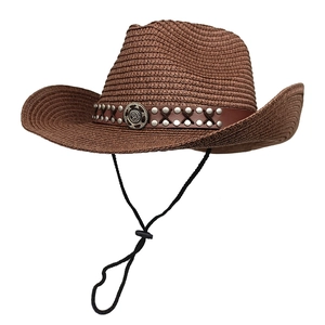 Detail of woven straw cowboy hat featuring brown leather band with silver metal rivets
