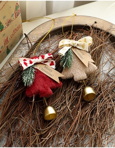 Detail of plush Christmas tree ornaments with golden bells and Merry Christmas tags