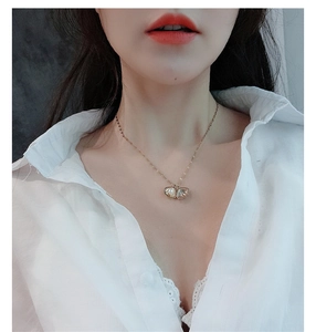 Close-up of 18k rose gold necklace with elegant shell pendant and white pearl detail