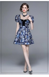 Detailed view of deep blue summer dress with lace neckline and black bow accent