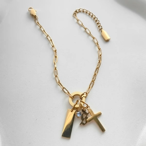 Detail view of gold-plated titanium steel bracelet with cross and rhinestone charms