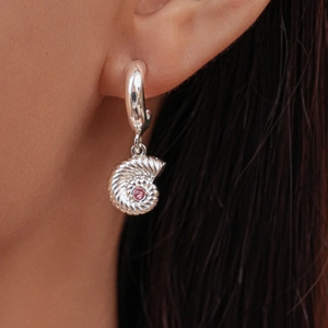 Detail view of silver nautilus seashell earring with a pink zircon stone inlay