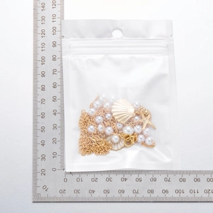 Close-up of bohemian shell and starfish pendant necklace with golden beads and measurement