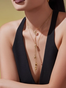 Détail du collier en Y doré avec pendentifs hippocampe, étoile de mer et pierres zircon