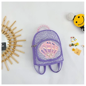 Close-up of a purple sequined shell backpack with a pink beaded handle for girls