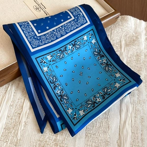 Detail of blue paisley fabric scarf necklace with ethnic patterns on textured backdrop