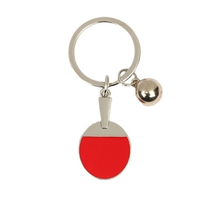 Red enamel table tennis paddle keychain with silver metal ring and bell on white background