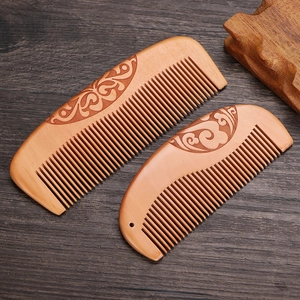 Natural peach wood comb set with elegant floral carving on dark wood tabletop
