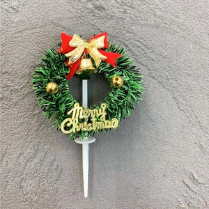 Christmas wreath cake topper with red bow and gold Merry Christmas sign on grey background