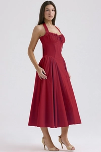 Close-up of red halter neck dress featuring corset-style bodice and pleated skirt detail