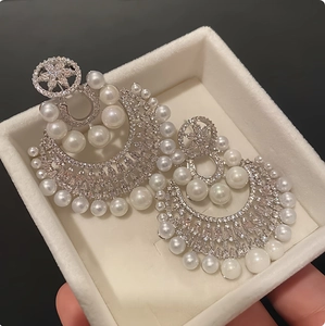 Elegant silver-toned floral drop earrings featuring pearls and sparkling rhinestones