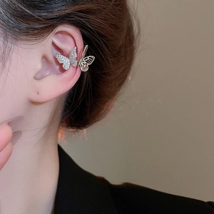 Detail of silver butterfly ear cuff with sparkling zircon crystals on female ear model