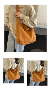 Detailed close-up of a large khaki canvas messenger bag featuring a front pocket and wide strap