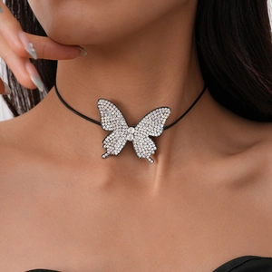 Close-up of a black choker necklace featuring a sparkling crystal butterfly pendant on a model