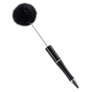 DIY beaded ballpoint pen featuring a soft black plush pom-pom and sleek metallic accents