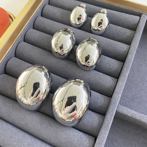 Three sizes of polished silver water drop earrings displayed on a grey velvet jewelry tray