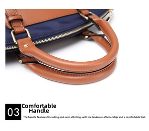 Close-up of brown leather handles and gold metal hardware on navy blue oxford bag