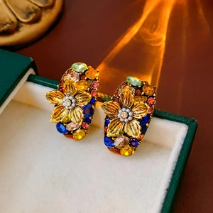 Close-up of vintage floral earrings with colorful crystals and pearls in a jewelry box