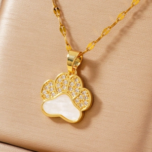 Macro shot of gold cat paw pendant featuring sparkling cubic zirconia and pearl shell inlay