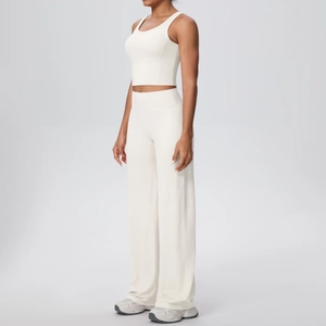 Dettaglio del set yoga crema con pantaloni a vita alta e canotta sportiva elastica