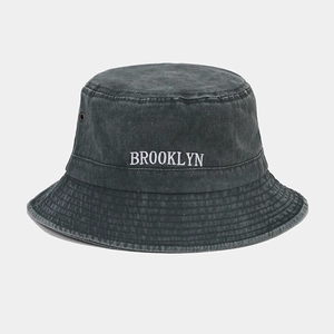 Détail de la broderie Brooklyn et des œillets métalliques sur le chapeau bob gris