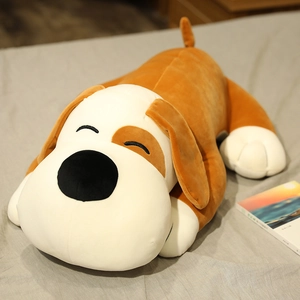 Detail of soft brown plush dog toy with closed-eye embroidery lying on a cozy bed