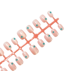 Pink cat eye press-on nails featuring a 3D green bead accent on white background