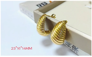 Detail showing 23x16x14mm gold croissant ribbed C-shaped earrings with mirror finish