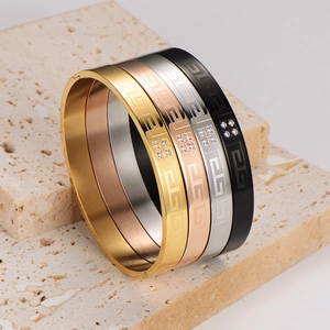 Set of four stainless steel bangles with Greek meander pattern and tiny zircon accents